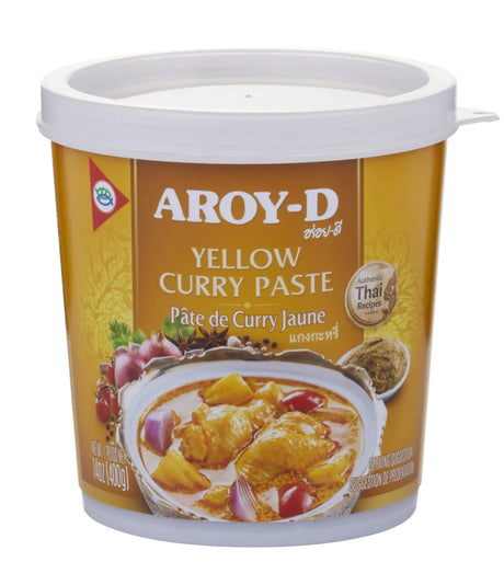 A container of Aroy-D Yellow Curry Paste with a picture of a prepared dish on the label, indicating the product is a packaged food item.
