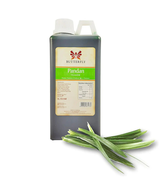 A bottle of Butterfly Pandan Flavouring Extract Paste with a green label, alongside fresh pandan leaves.
