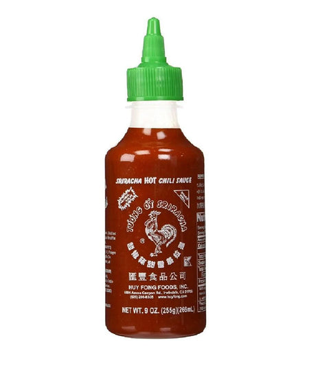 A bottle of Huy Fong Foods Sriracha Hot Chili Sauce with a green cap and label featuring Chinese characters.