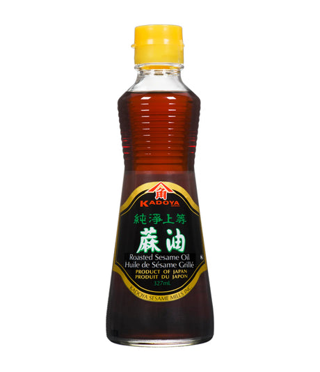 A bottle of Kadoya Roasted Sesame Oil 100% Pure with a yellow cap on a white background.