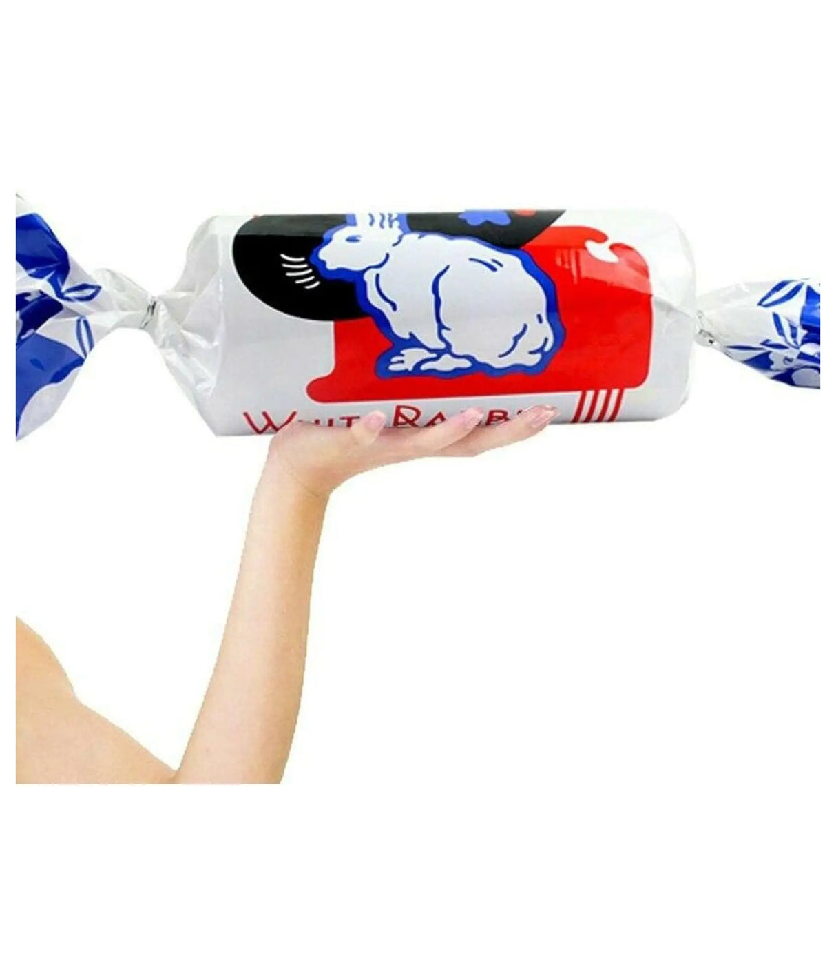 Hand holding a wrapped White Rabbit candy bar against a white background