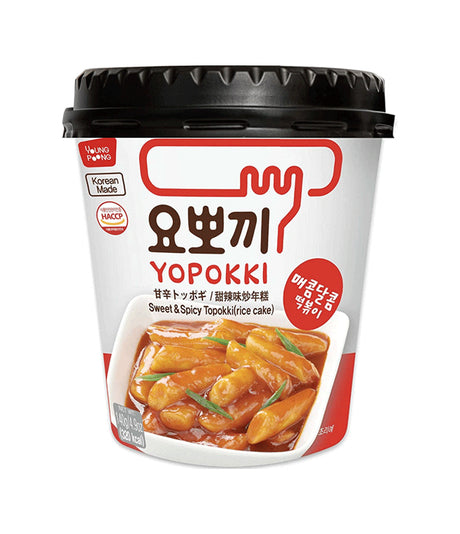 A packaged product of Young Poong Yopokki Sweet & Spicy Topokki, a Korean instant noodle dish, in a white cup with red and black text, and an image of the noodles on the front.