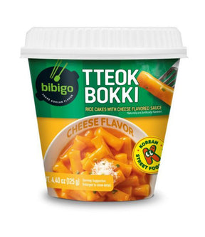 A packaged product of Bibigo Tteokbokki Rice Cakes with Cheese Flavored Sauce, showing the product name, an image of the cheese-flavored rice cakes, and the Korean flag indicating its origin.
