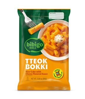 Packaging of bibigo Tteok Bokki with a bowl of rice cake and cheese sauce on a white background
