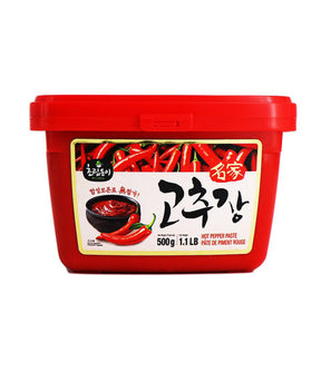 A red plastic container of Choripdong Hot Pepper Paste with Korean text and an image of chili peppers on the label.