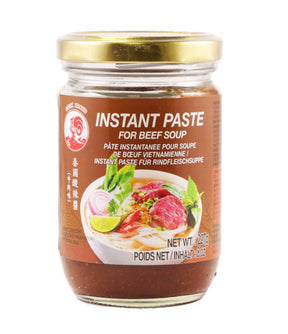 A jar of Cock Brand Instant Paste for Beef Soup, 227g, with a label that includes a picture of the soup and ingredients like beef, lime, and chili.