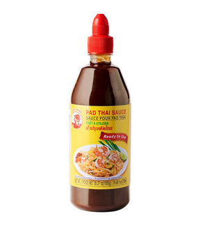 Bottle of Cock Brand Pad Thai Sauce with a red cap on a white background.