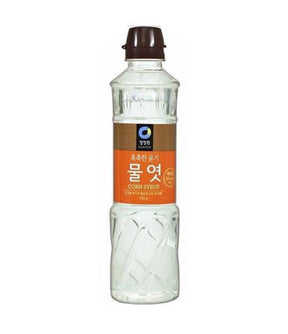A bottle of Daesang corn syrup with Korean labeling, predominantly clear in color with a white cap.