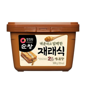 A packaged product of Daesang Soy Bean Paste (Sunchang Doenjang) with a label showing the product name and an image of soybeans, contained in a brown plastic bucket.