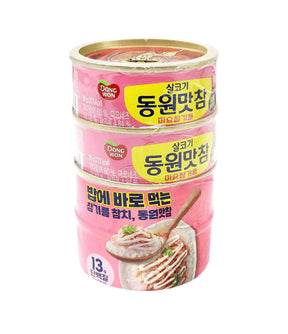 Four stacked cans of Dongwon Tuna on a plain white background.