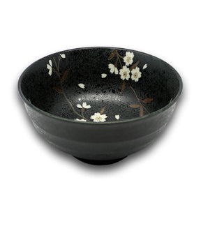 Black ceramic bowl with white floral design on a white background