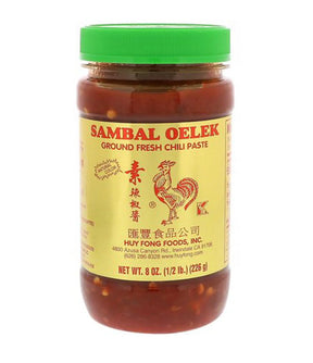 A jar of Sambal Oelek ground fresh chili paste with a green lid and a label featuring an illustration of a rooster. The product is made in the U.