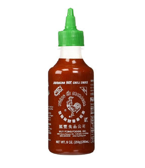A bottle of Huy Fong Foods Sriracha Hot Chili Sauce with a green cap and label featuring Chinese characters.