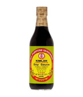 A bottle of Kimlan Less Sodium Soy Sauce with a yellow label, predominantly dark colored sauce visible through the transparent glass.