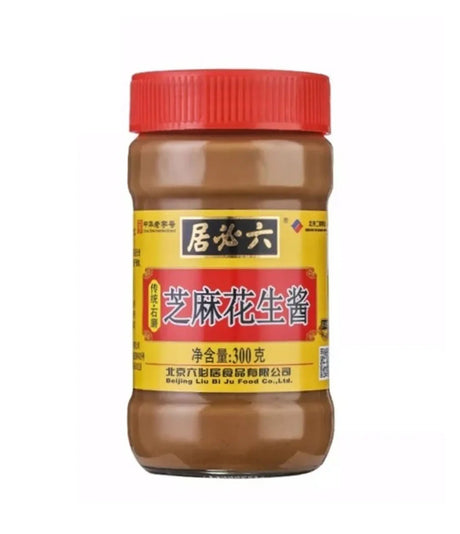 Jar of sesame peanut sauce with a red lid on a white background