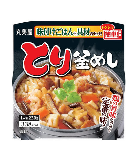 Front-facing package of Japanese instant rice with vegetables and meat, showing a bowl of prepared rice on the front with large red and white Japanese text and a dark background.