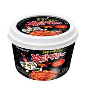 A cup of Samyang Buldak Topokki, which is a spicy Korean instant noodle product, with an illustration of noodles and a chicken on the packaging.