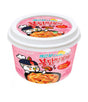 A packaged product of Samyang Buldak Topokki (Carbo) showing the product name and an image of the spicy noodles on a pink background.
