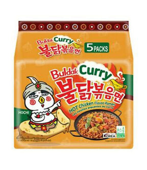 Packaging for Samyang Spicy Chicken Buldak Noodle (Curry) showing an illustration of a character eating noodles and the text indicating it is a hot chicken flavor ramen. The package mentions it includes 5 packs.