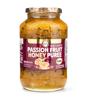 A jar of Surasang Passion Fruit Honey Puree with a label showing the product name and an image of passion fruit. The jar is sealed and presented against a white background.