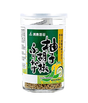 A clear plastic jar of Yuzu Pepper seasoning with a green and white label featuring Japanese text and a yellow lemon illustration, containing brownish seasoning flakes visible at the bottom.