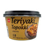 Container of Teriyaki Topokki with a black lid on a white background